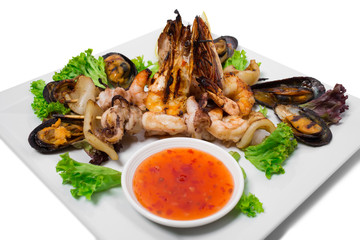 Grilled seafood platter with hot sauce.