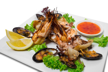 Grilled seafood platter with hot sauce.