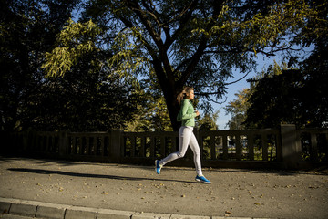 Fototapeta premium Young woman running in the park