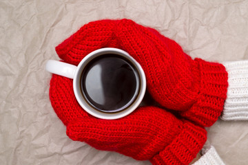 Woman in mittens and cup of coffee