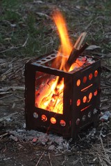 Tourist mini stove in the autumn forest