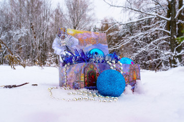 Christmas decorations in a box in the snow in the winter forest