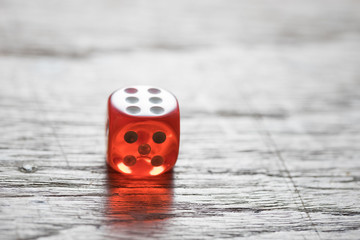 One Red Dice on Wooden Table
