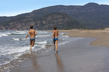 two friends kids boys running on beach photo