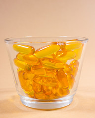 Omega 3 capsules from fish oil on pastel background.