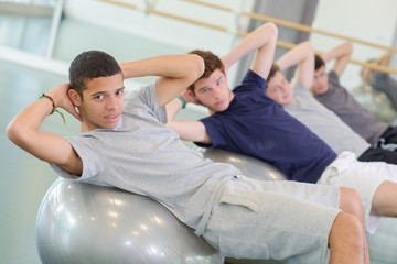 men on top of gym ball