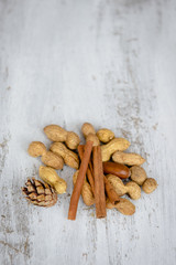 Cinnamon, cones, walnut on a white wooden table