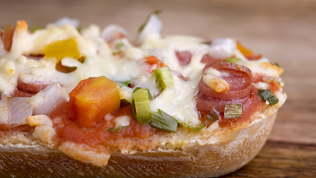 macro baked baguette with salami, cheese and vegetable