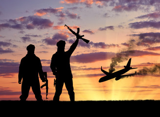 Fototapeta na wymiar Silhouette of armed men and plane crashing