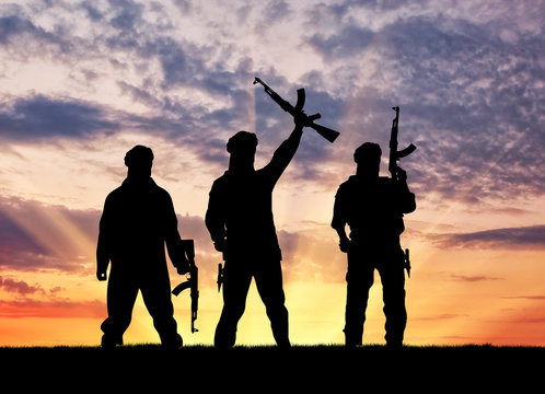 Silhouette of men with rifle during sunset