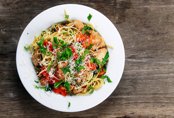 Italian Chicken Breast spaghetti with red pepper, Parmesan cheese and wild rocket  lives. on old wooden table.