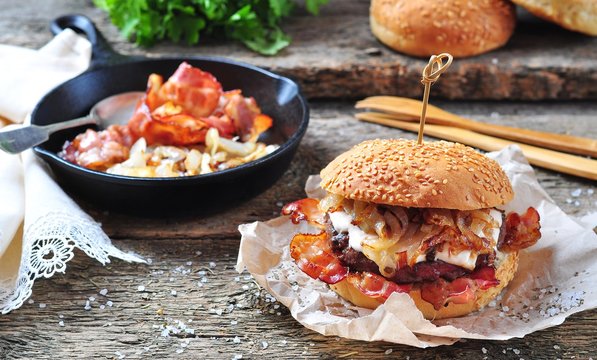 juicy homemade double burger beef with fried onions on a wooden background