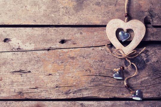 Rustic decorative heart on aged wooden  background.