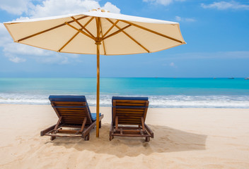 Beach chairs with umbrella and beach on a sunny day