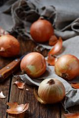Raw onions on wooden background