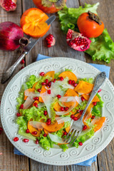 Vitamin salad with persimmon, cheese and pomegranate seeds.