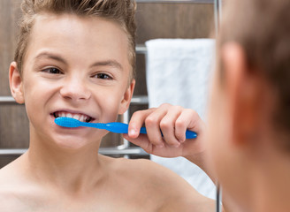 Teen boy brushing his teeth