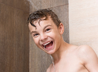 Cheerful boy washing body in bath