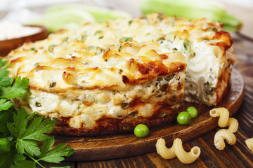 Casserole of pasta with green peas, zucchini and curd