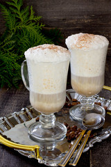 Cappuccino with a decorated Christmas tree on a wooden table
