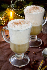 Cappuccino with a decorated Christmas tree on a wooden table