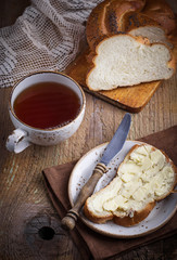 Homemade bread with butter on wooden background