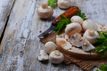 Raw champignon mushroom on wooden background