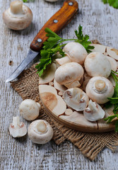 Raw champignon mushroom on wooden background