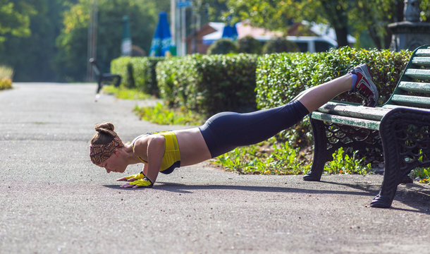 Fitness woman doing push-ups during outdoor cross training workout