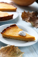 Tasty pumpkin pie on plate on a blue wooden table