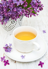 Cup of tea and lilac flowers