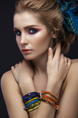 Beautiful fashion girl in a scarf and bracelets boho style. Beauty face, bright trendy makeup