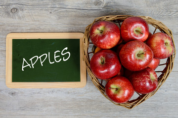 red apples in basket with a small slate