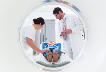 Arzt, Patientin und Krankenschwester bei CT Tompgraphie im Krankenhaus, Bild durch die Röhre des...