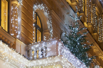 Building facade with light decoration at night with Christmas tr