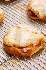Fresh sweet roll with icing in bakery