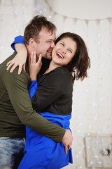Young husband and wife laugh in Christmas decorate room
