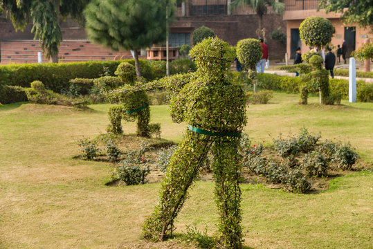 Topiary hedge figures depicting British soldiers firing rifles at the site of the Jallianwala Bagh massacre in Amritsar, India.