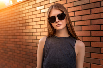 Portrait of Young Woman on Brick Wall Background.