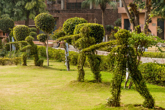 Topiary hedge figures depicting British soldiers firing rifles at the site of the Jallianwala Bagh massacre in Amritsar, India.