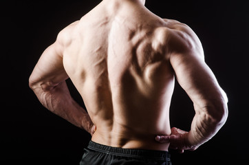 Fototapeta premium Muscular man posing in dark studio