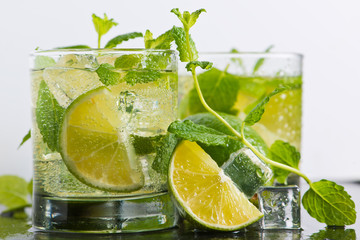 Mojito cocktail with fresh limes, mint and ice, selective focus