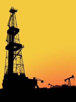 Silhouette of drilling rig on the oil&gas field with mountains and sunset