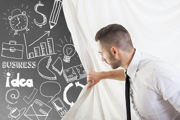 young businessman looks at sketches of graphic symbols on the wa