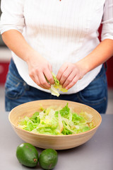 Young woman making salad