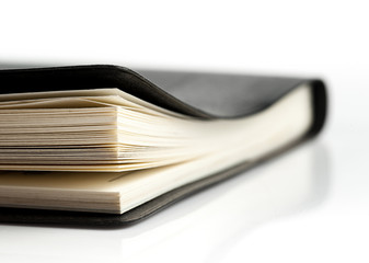 Black leather notebook on white background