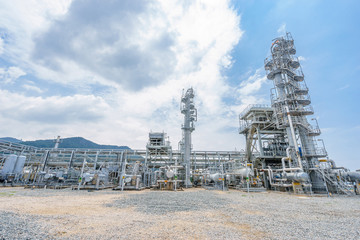 oil refinery stands  in cloudy sky