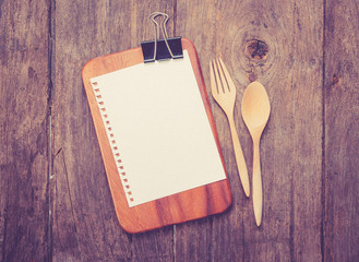 Blank clip menu sheet of paper and spoon on rustic wooden