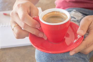 Woman in torn jeans sitting at coffee shop
