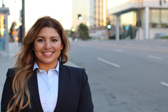Image of beautiful Hispanic businesswoman while standing on the road